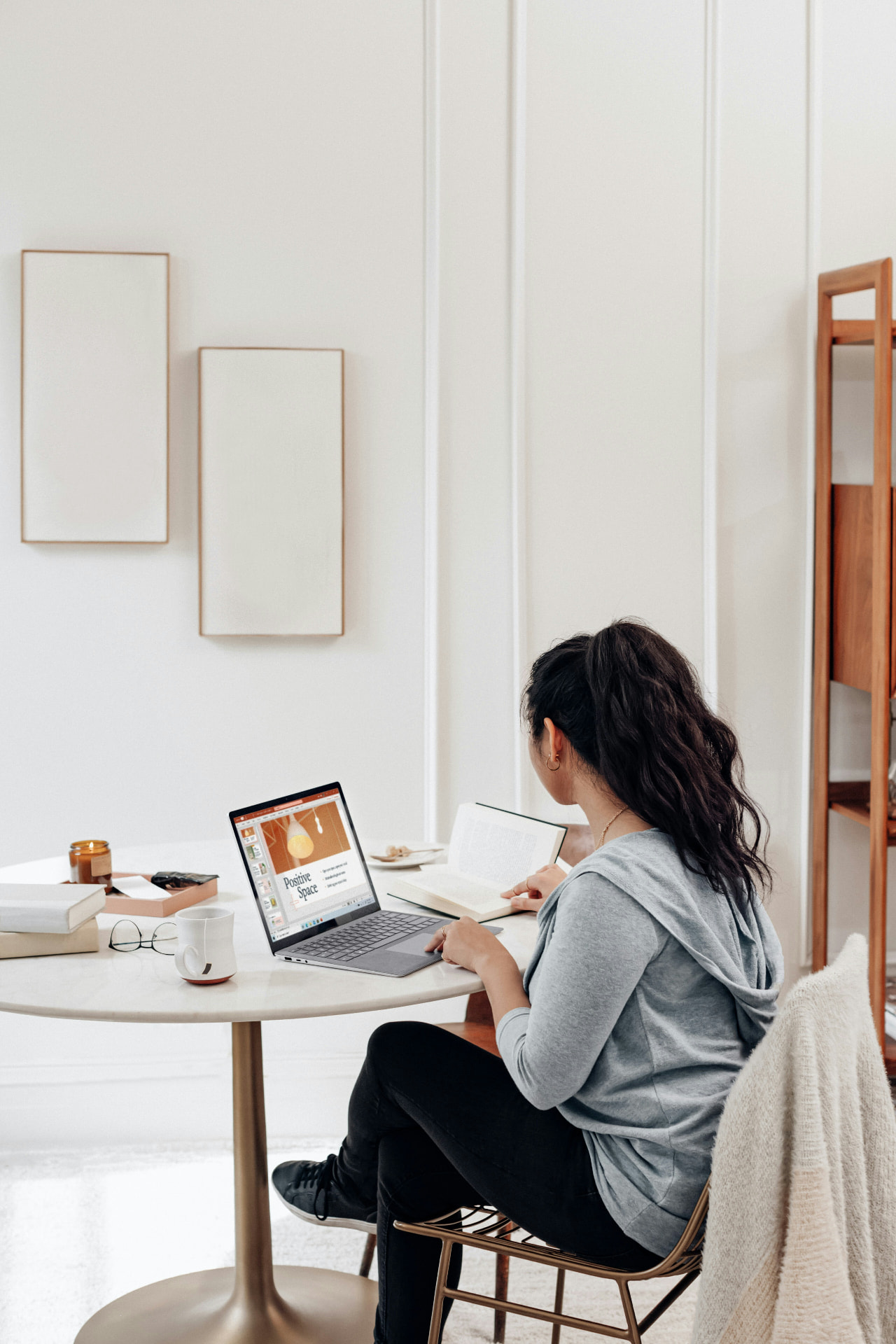 A woman working quietly at a laptop at a table at home